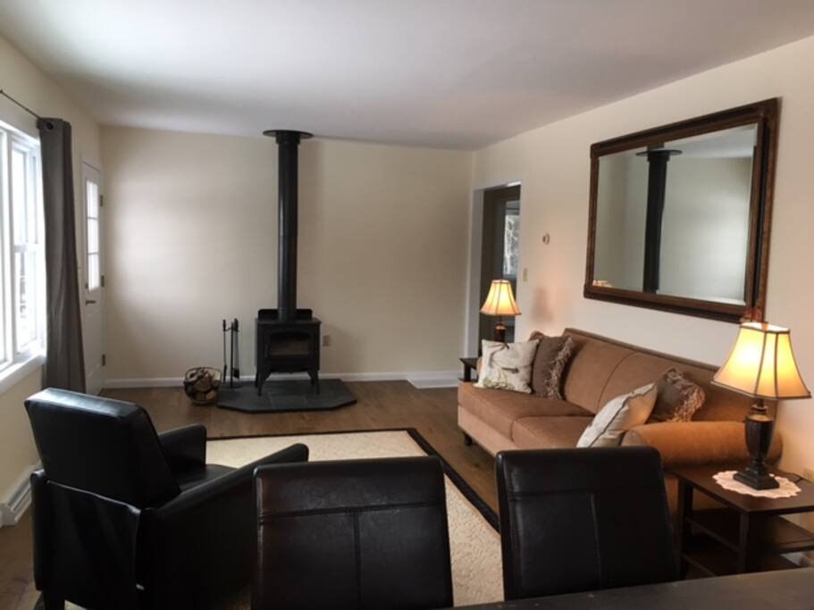 Living room with wood stove is open to dining area and has great views.