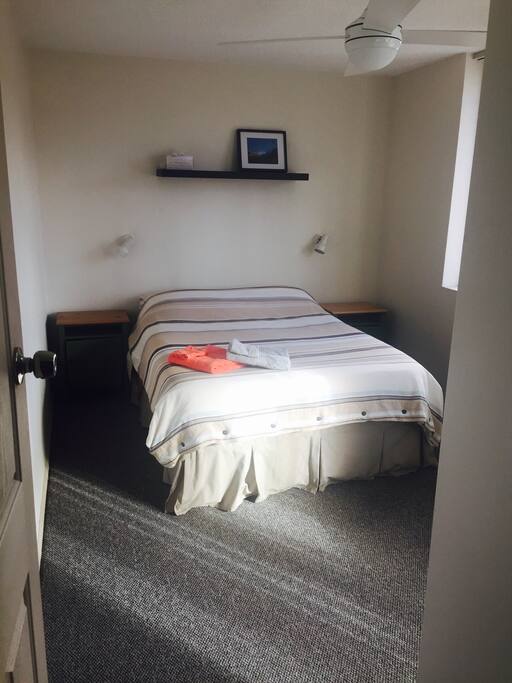 The bedroom with a fan, mirror and cupboard space.