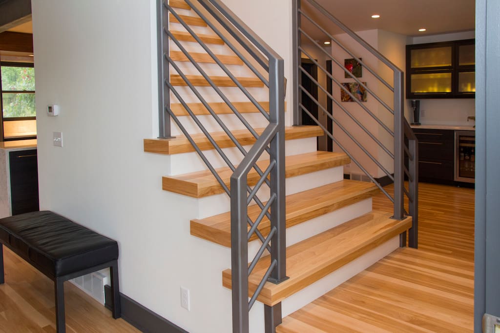 Entryway with open stairs connecting living room and dining room.