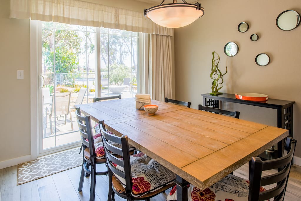 A wood dining table seats six with views of Morro Rock through the patio door
