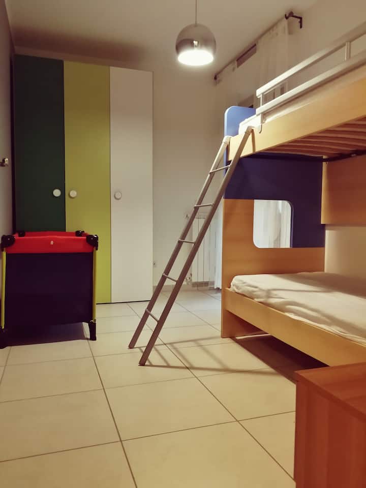 Dhomë gjumi me krevat marinari, krevat fëmijësh dhe ballkon.