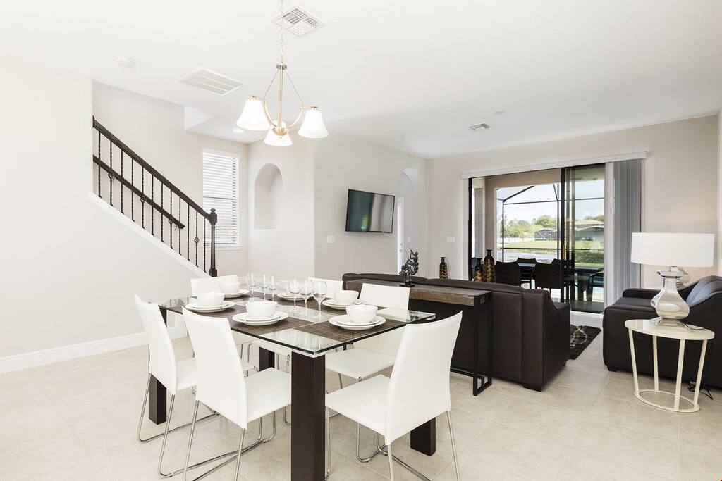 The living area is bright and spacious, featuring a dining table and a sitting area with a TV.