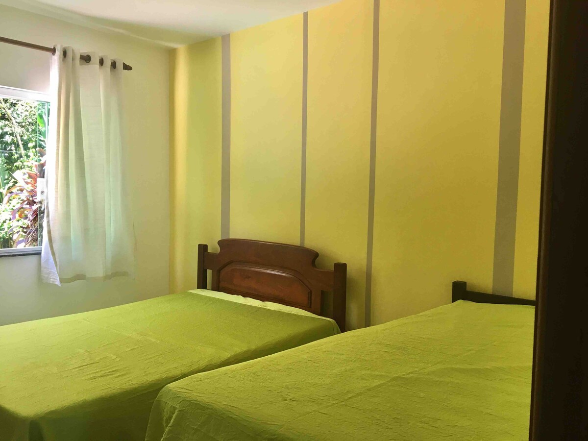 Spálňa na prízemí s výhľadom na bazén so stropným ventilátorom