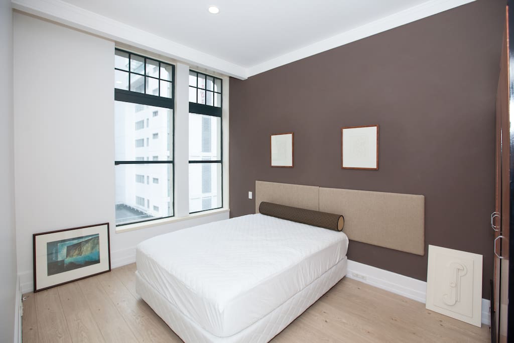A comfortable queen bed with large window overlooking Hobson Street.