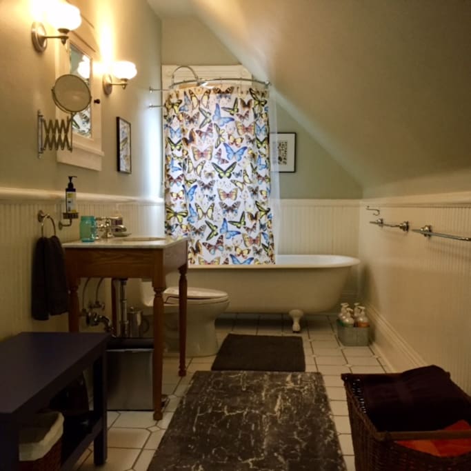 Private bathroom with claw foot tub and natural shampoos and soaps.