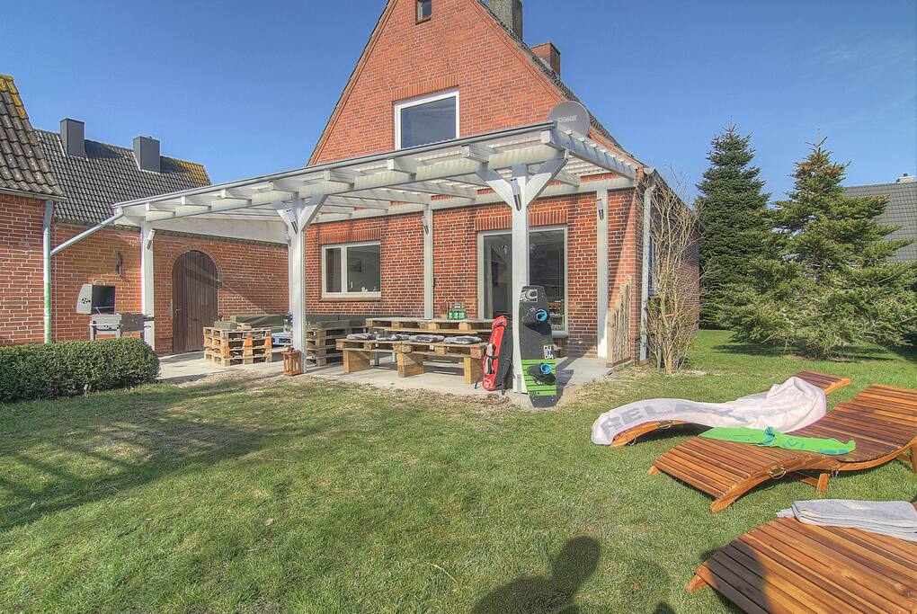 Die wunderschöne große Terrasse ist komplett überdacht, hat direkte Südlage und somit den ganzen Tag Sonne. Die großzügige Sitzlounge lädt zum Entspannen ein. Ein großer Holzkohle-Grill, für einen Grillabend, ist auch vorhanden. Außerdem gibt es noch Sonnenliegen, sowie einen Strandkorb.