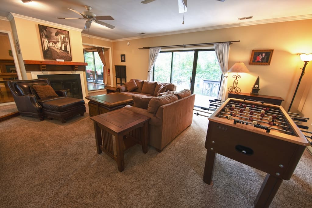 Living room with fireplace, comfy couches and foosball table