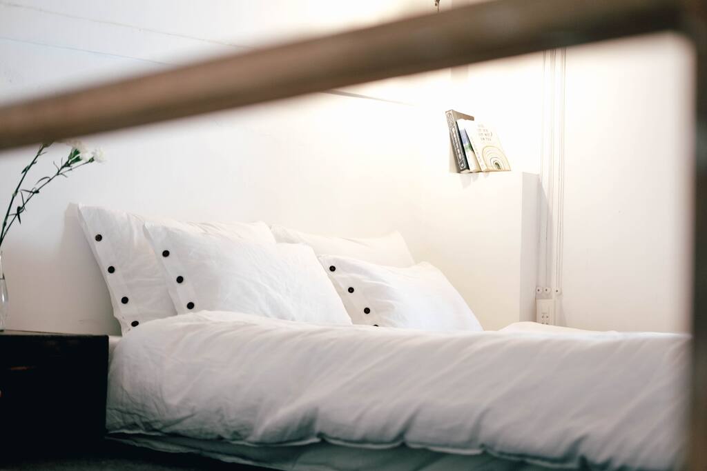 A bed put on the attic, next to a sunny window for your tight sleep.