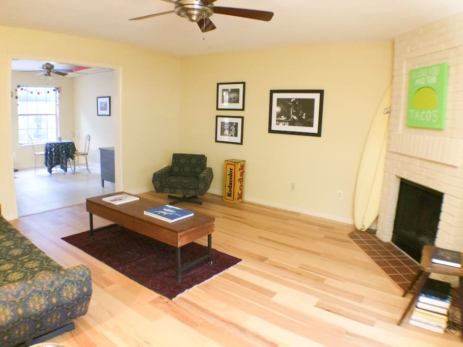 Spacious living room, with hickory floors, unique mid-century furniture, and original artwork.