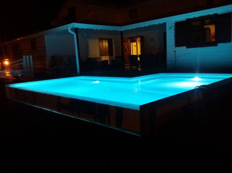 Piscine à débordement, éclairée le soir