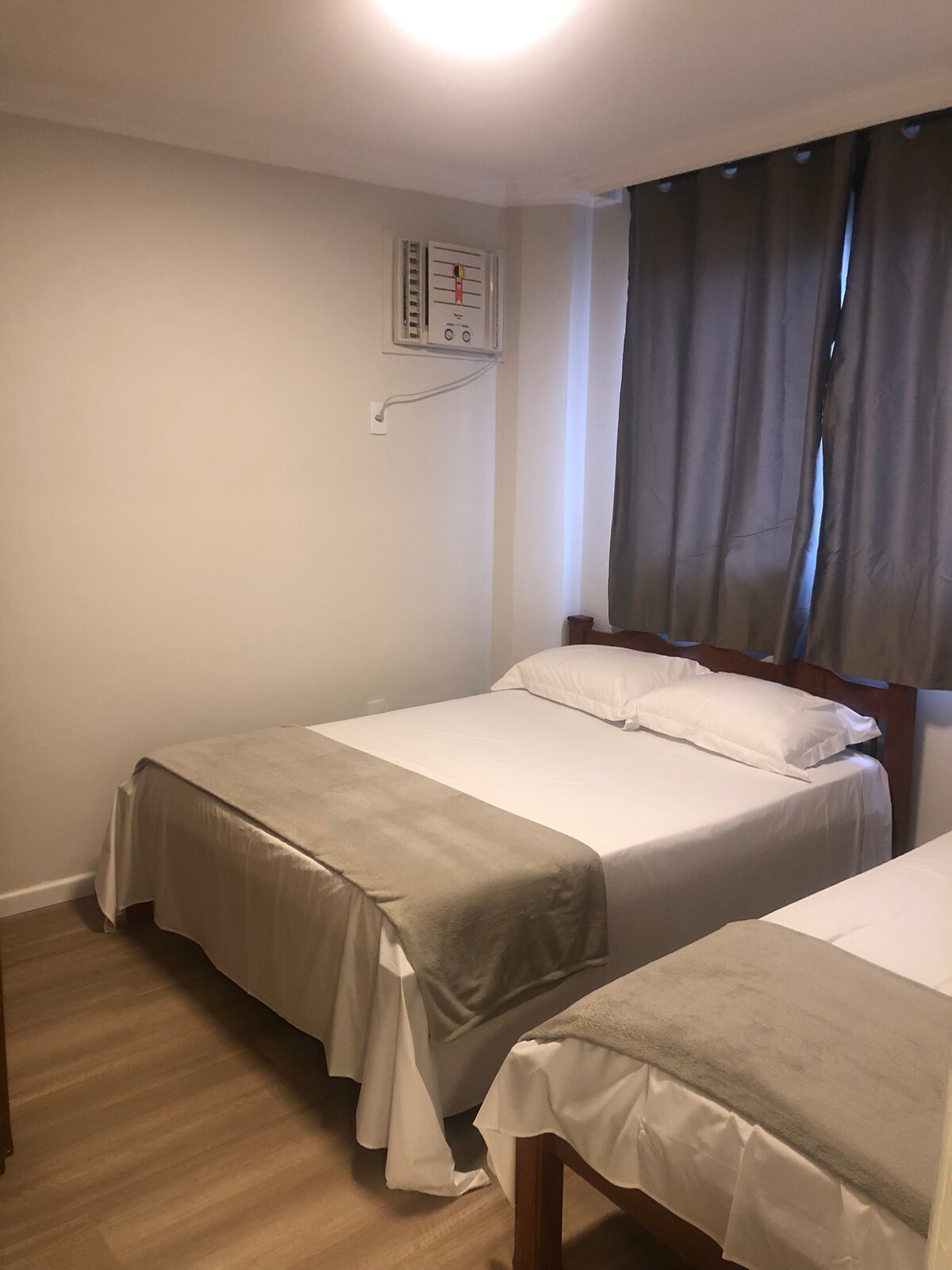 Habitación con 1 cama individual, 1 cama matrimonial y aire acondicionado.