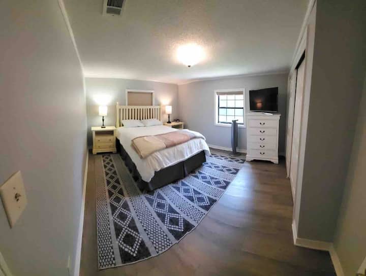 Gastenslaapkamer met queensize bed en grote kast.