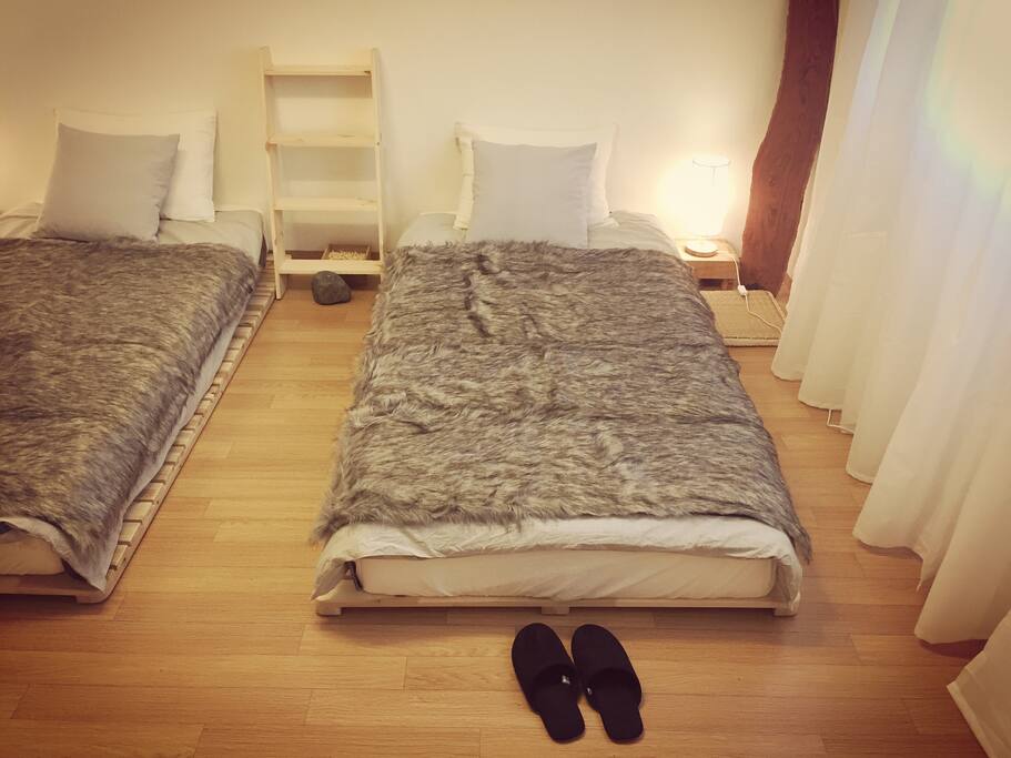 A twin-bed room with a table, chair, stand, air conditioner, clothing rack, shelf, hair drier, towels, humidifier and organic aroma diffuser. Each room connects to fast WiFi.