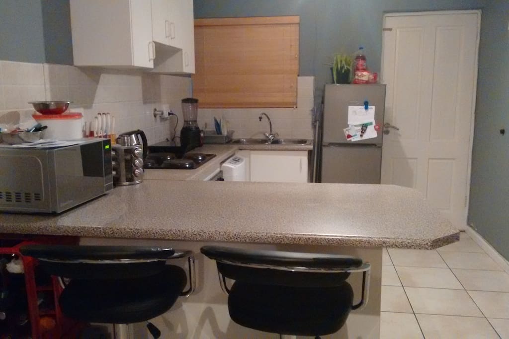 The kitchen with stools and a surface to work or eat on