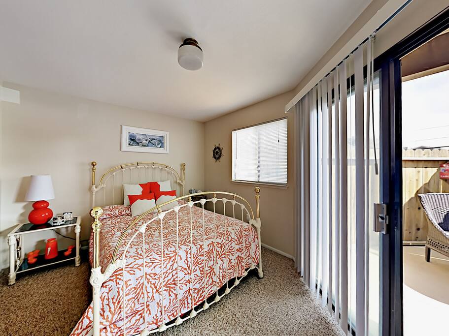Cute 3rd bedroom with queen wrought-iron bed and door to the back patio.