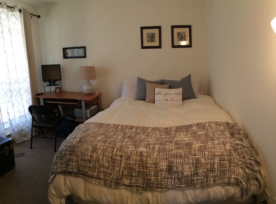 Guest bedroom. Queen bed, desk, bedside lamp and floor lighting. Window looks out onto greenbelt with great privacy. Sheers let in light while providing privacy, and curtains block out light for darkness at night.