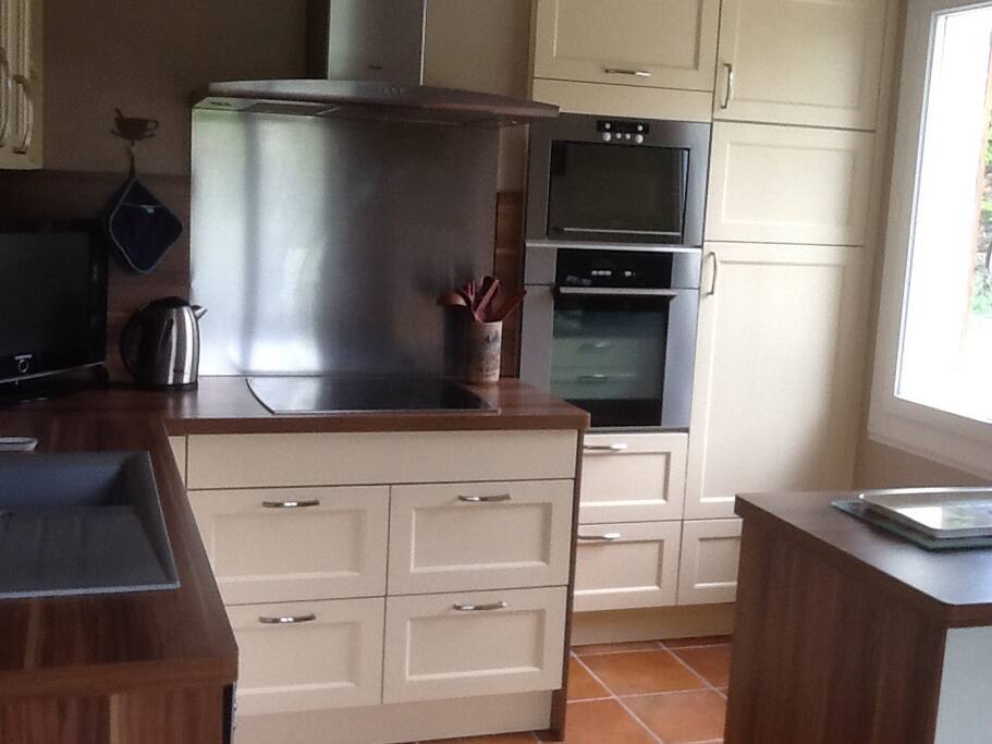 Cuisine amenagee avec lave vaisselle, four, micro ondes, refrigerateur, vaisselle.