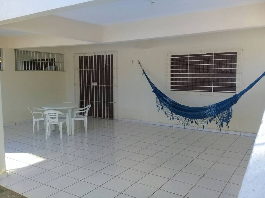 Terraço garagem (5,50 x 7,00 metros) equipado com mesa plástica com 04 cadeiras e rede para casal.