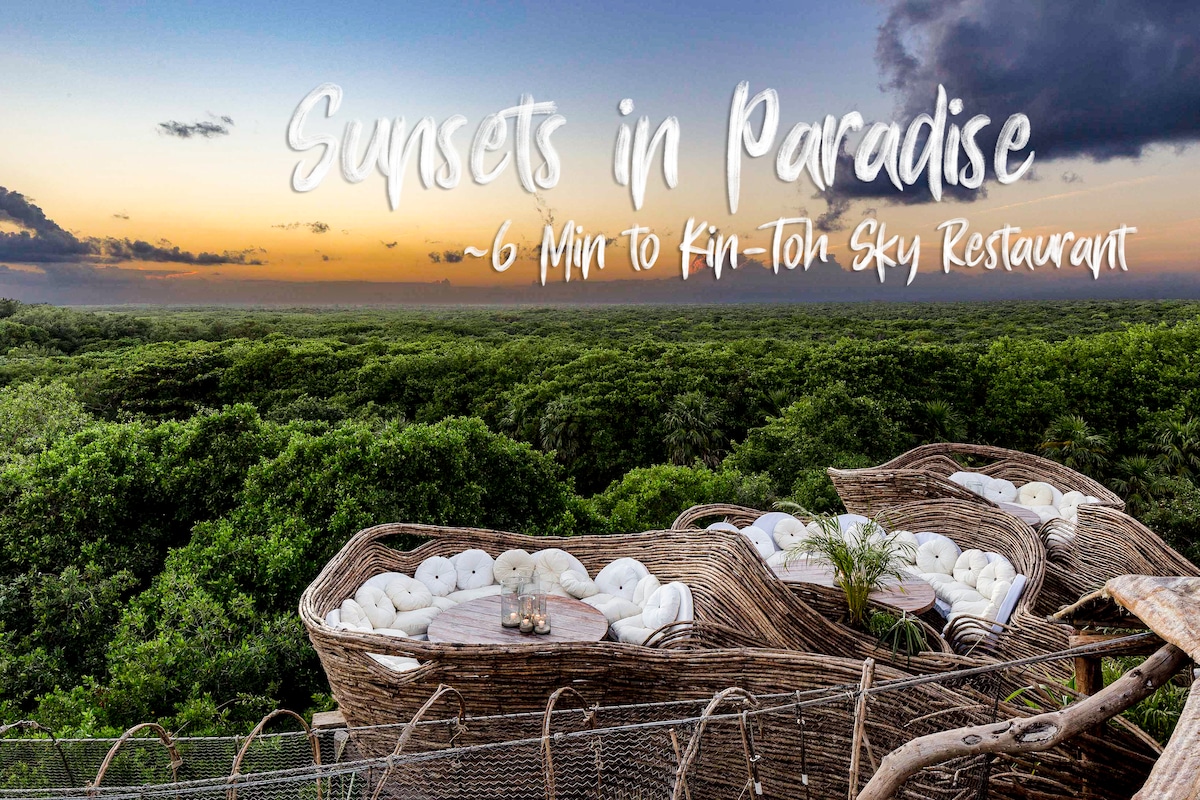 A scenic view showcases inviting outdoor seating crafted from natural materials, offering a peaceful space to enjoy sunsets. The backdrop displays a rich jungle landscape under a gradient sky transitioning from blue to orange, hinting at the beauty of evening moments.