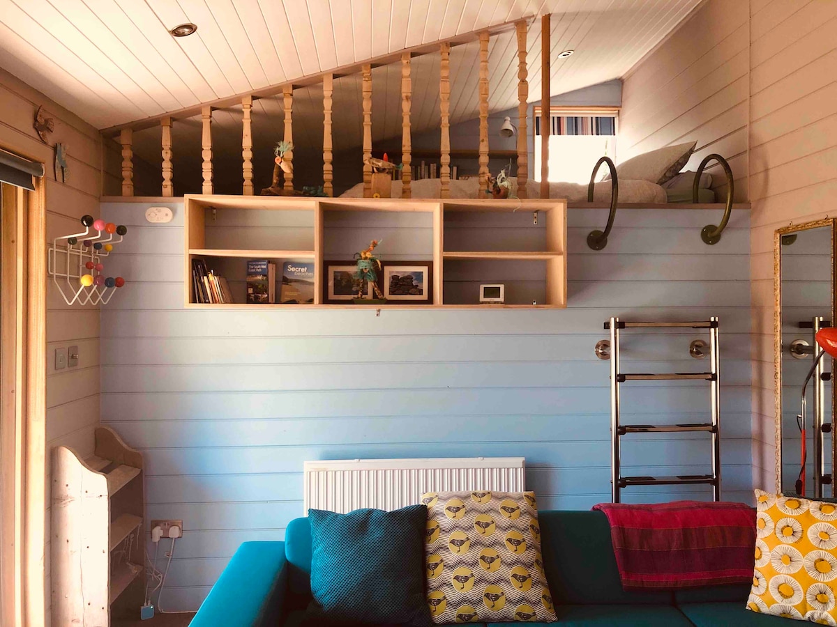 Საძილე ტერასა დიდი ზომის საწოლზე, რომელიც ხელმისაწვდომია კიბით, სათავსოებით, ტანსაცმლის დასაკიდი და ფეხსაცმლის თაროებით.
