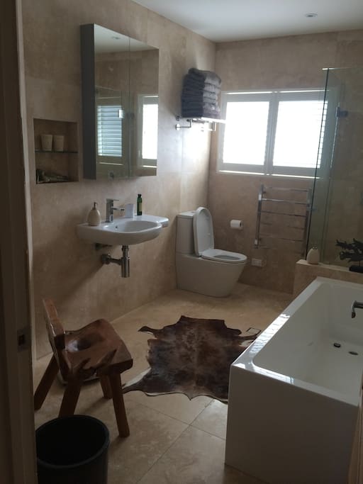 Beautiful airy travertine shared bathroom