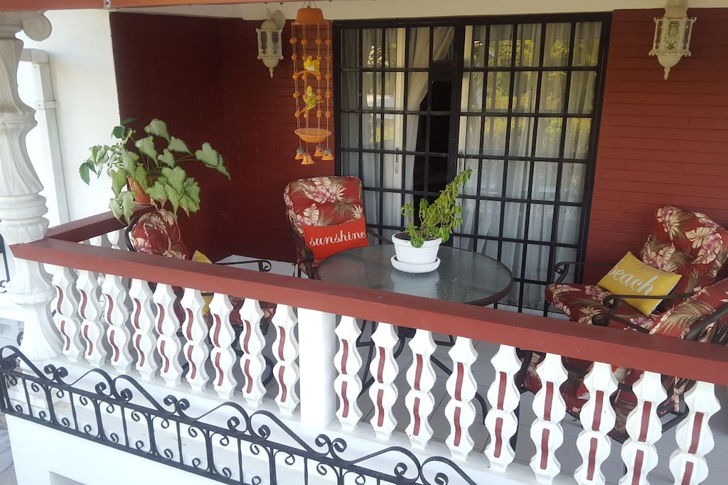 1 of 2 porches with hill and garden views. Facing the breeze so always cool. A great place for a drink at sunset.