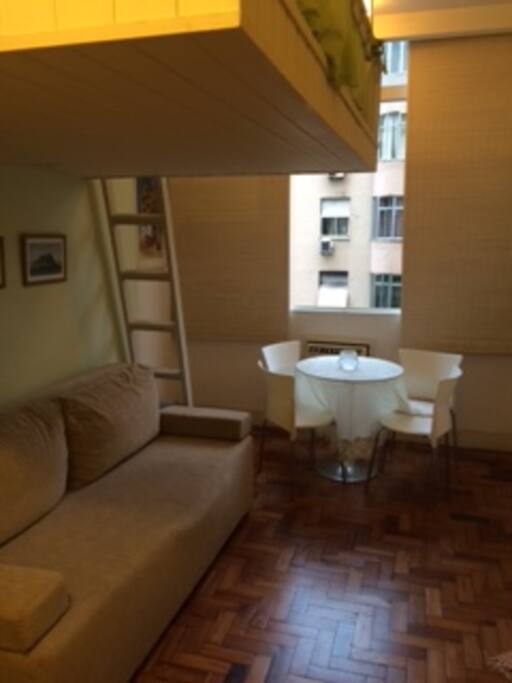 Sofá-cama e mesa de vidro com quatro cadeiras