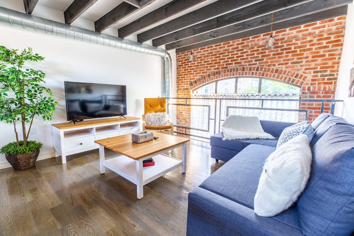 (Living Room) Located on the duplex level of the loft. 50" Smart TV with access to local channels and apps like Netflix, HBO, Prime and more. Queen Size Sofa Bed with extra blankets and pillows. Beautiful window view of the neighborhood.