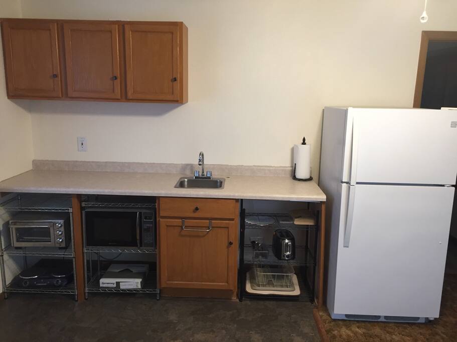 Personal kitchen area includes a counter top stove burner for basic cooking. There is a George Forman style mini grill for basic grilling with interchangeable plates for cooking waffles and other things. The fridge is equipped with an ice maker in the freezer. Microwave and toaster oven included along with pots, pans, dishes, and utensils.