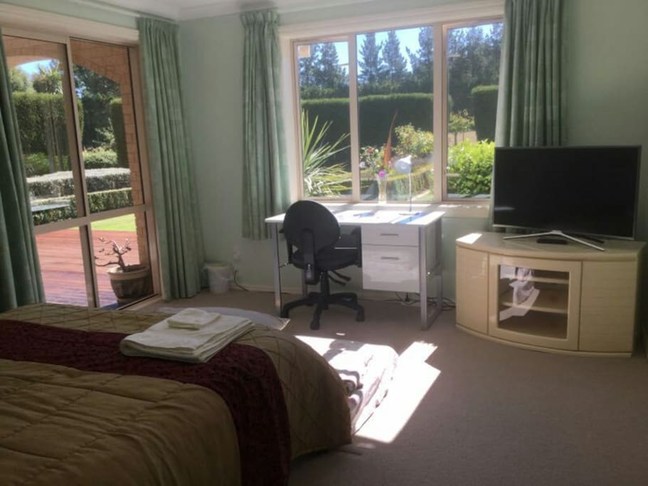 Ensuite bedroom overlooking the main garden. Sliding glass door leads out onto back porch.