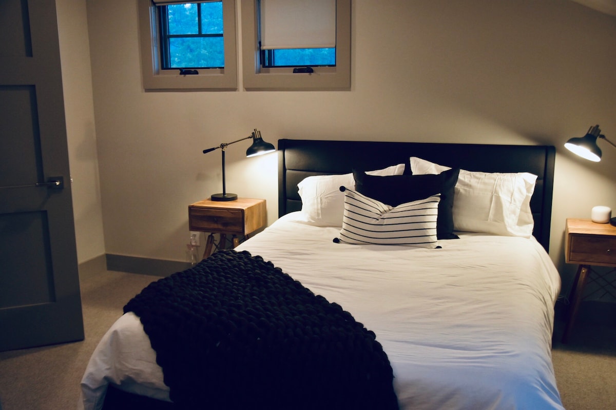 חדר אורחים עם מיטת קווין סייז צמודה.