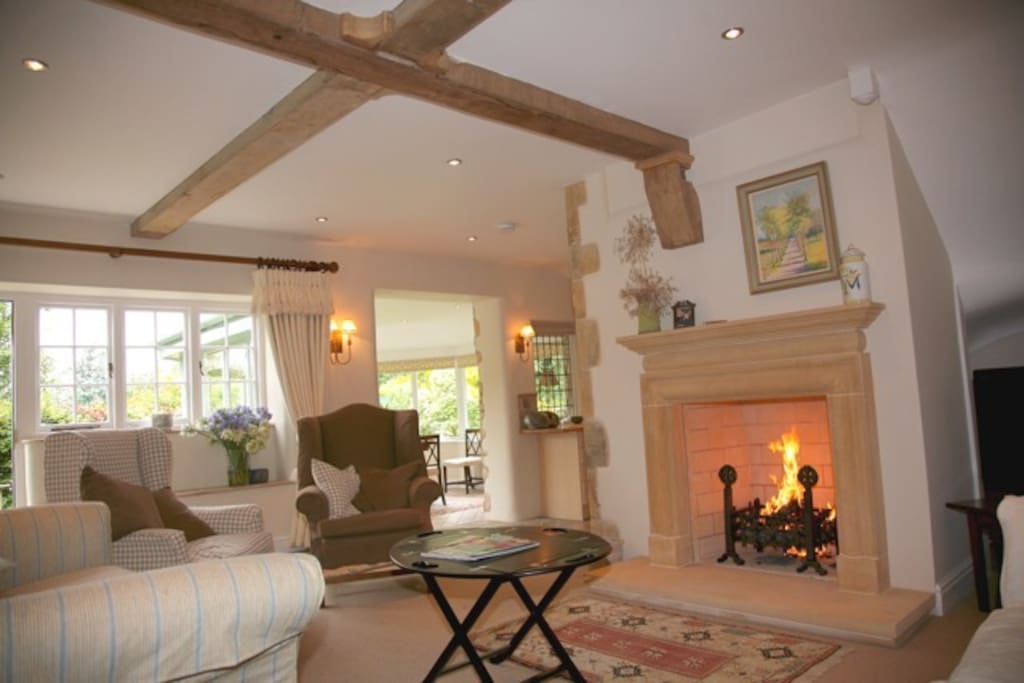 Sitting room - 2 sofas arm chairs open log fire - through to dining room conservatory- ( fireguard available )