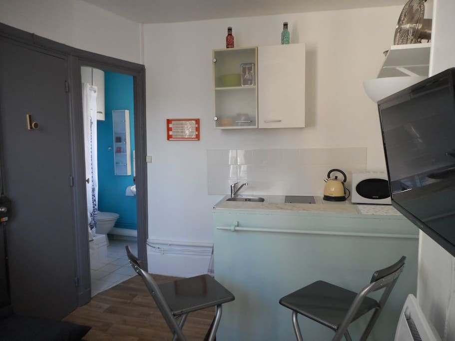 Vue sur le coin cuisine avec bar et chaises hautes