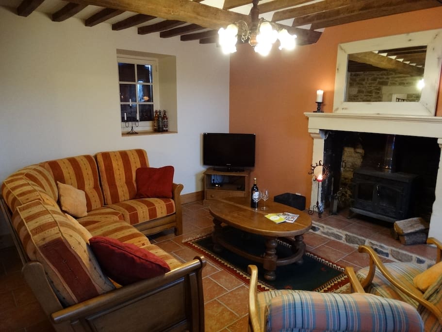 Living room with wood burning stove and beamed ceiling