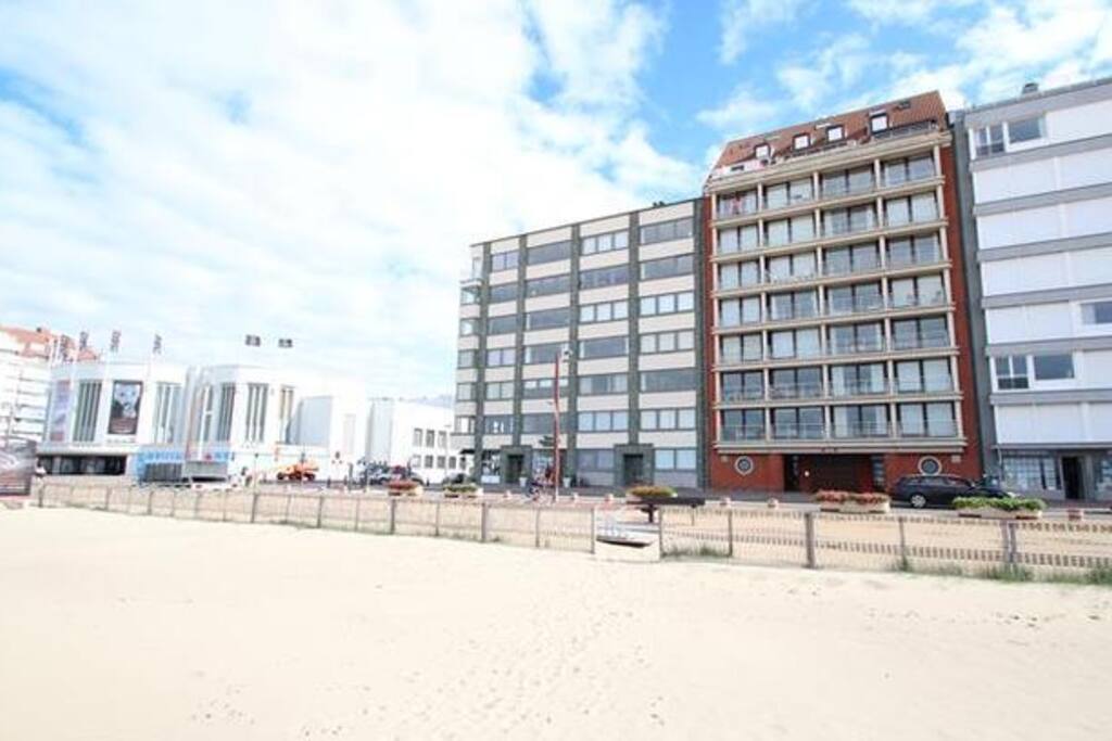 Vanaf strand gezien, in winter zonder de strandhuisjes. Het appartement nr 7-3 bevindt zich op de 7e verdieping, 3e van links, in het rode gebouw.