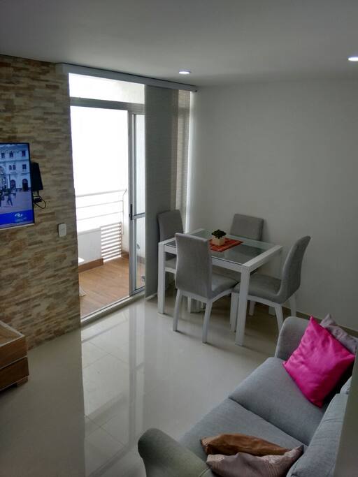 Sala comedor confortable con televisor 50 pulgadas vista al mar desde el balcon