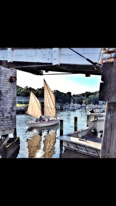 Sailboat passing through draw bridge in Perkins Cove.