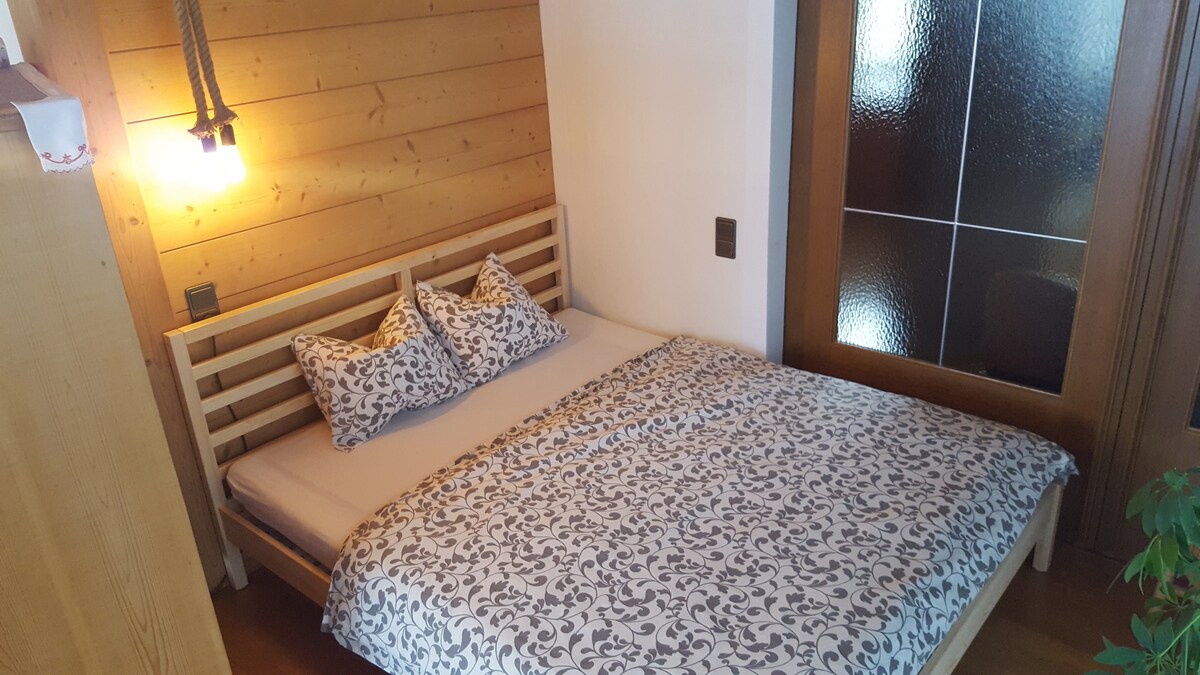 Bett im Wohnzimmer; abgetrennt durch Schiebtür (zum Esszimmer)