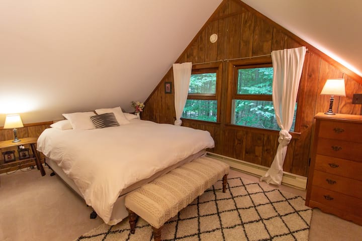 The Treetop Bedroom! Our wood-paneled master sweet sits on the second floor of the cabin, adjacent to its own full bath. It also has a big flat-screen smart TV