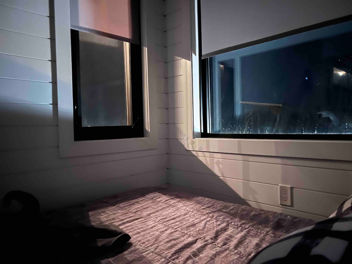 Pogled iz spavaće sobe na snijeg koji lagano pada!  Veliki prozor s kutnim prozorom i krovnim prozorom u kombinaciji s donjim krevetom pružaju pogled na noćno nebo! Dopustite prirodi da vas nježno probudi ili spustite rolete kako biste dobili dodatnu hladovinu! 