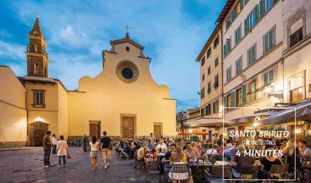 A vibrant piazza is populated with diners enjoying meals at outdoor tables. In the background, an historic church with a distinctive bell tower is visible, complemented by charming buildings. Soft evening light casts a warm glow over the scene.