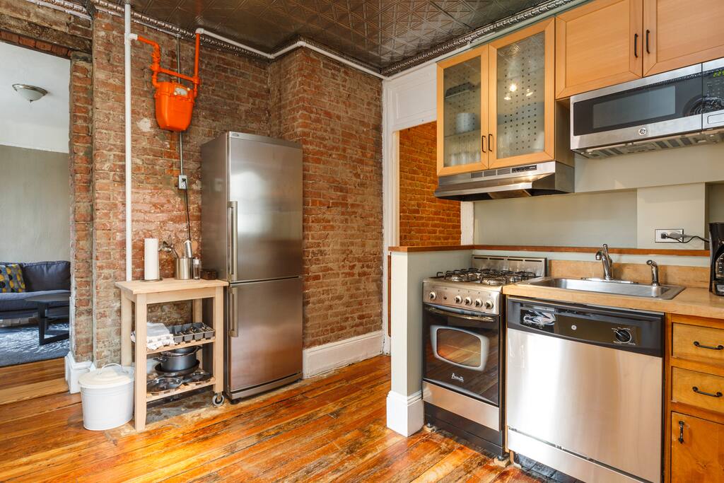 View of kitchen towards living space featuring original exposed brick.