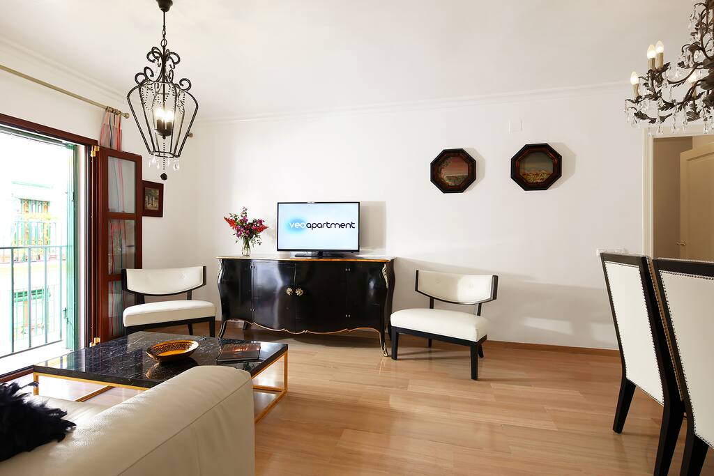 Living room furnished with sofa, 2 armchairs, coffee table and TV.