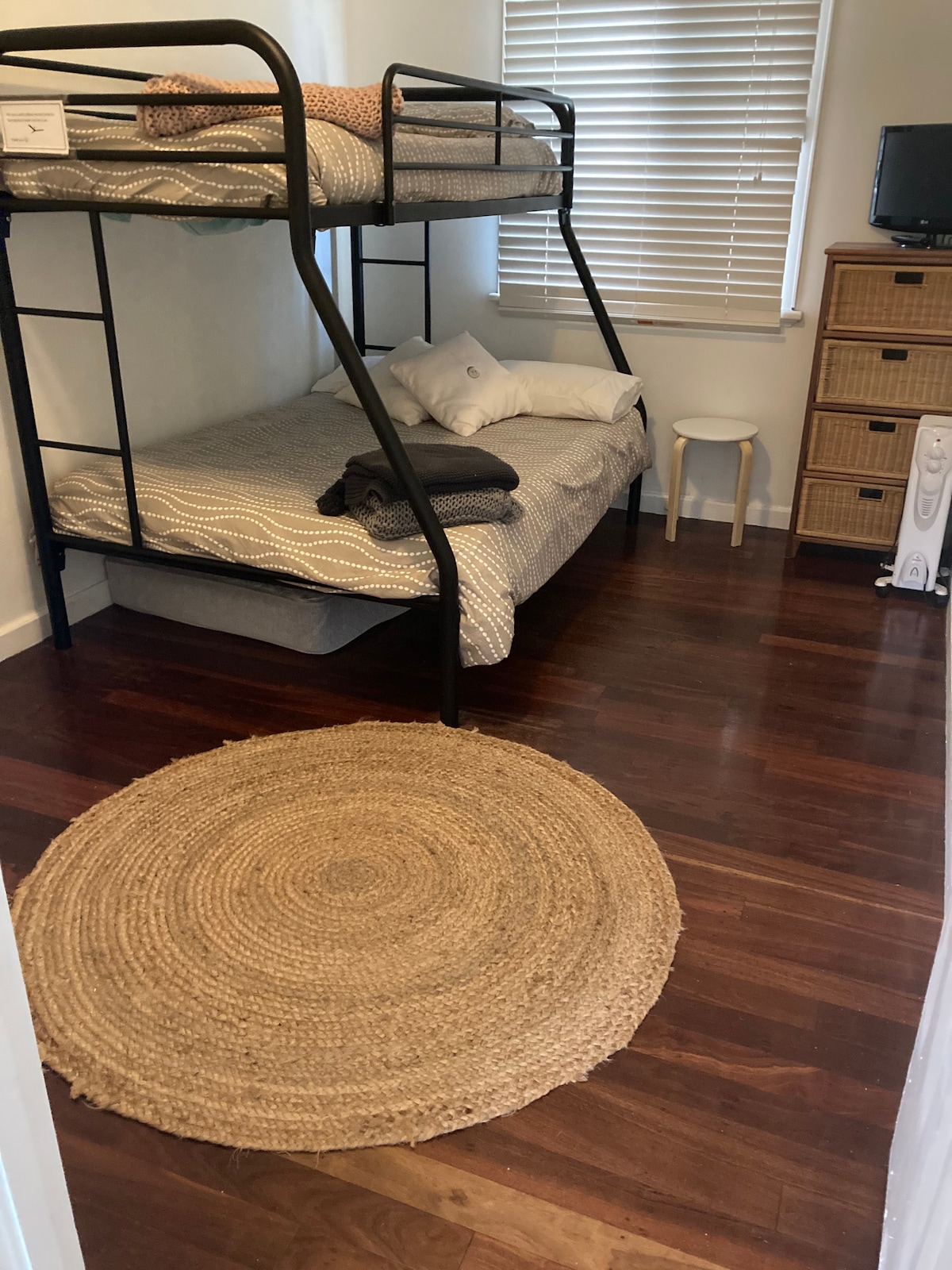 中间卧室配有双层和单人双层床。 抽屉顶部的小电视。网球拍。