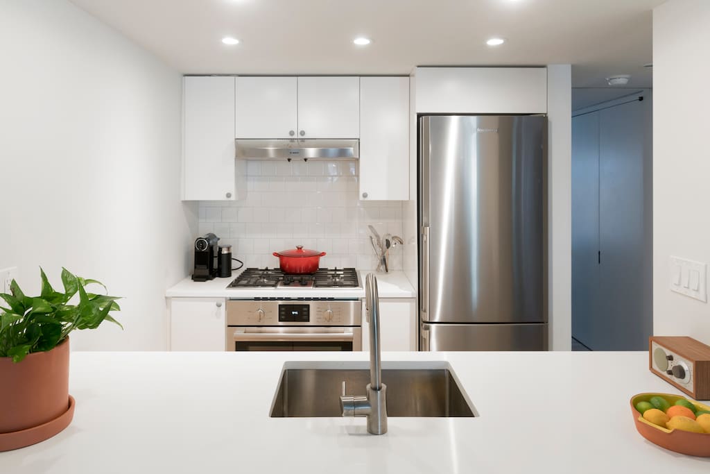 Full kitchen with, dishwasher and dining counter.