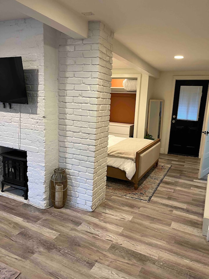 Brick wall offers the bedroom privacy from the living room. Directly back is the door to the backyard. There is a shade on the door for privacy and to limit external light and a full length mirror for your convenience.