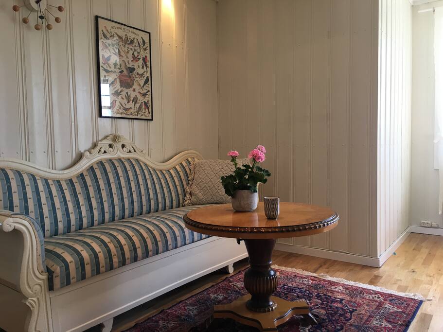 Stort kjøkken med sofa og peis i tillegg til spisebord.