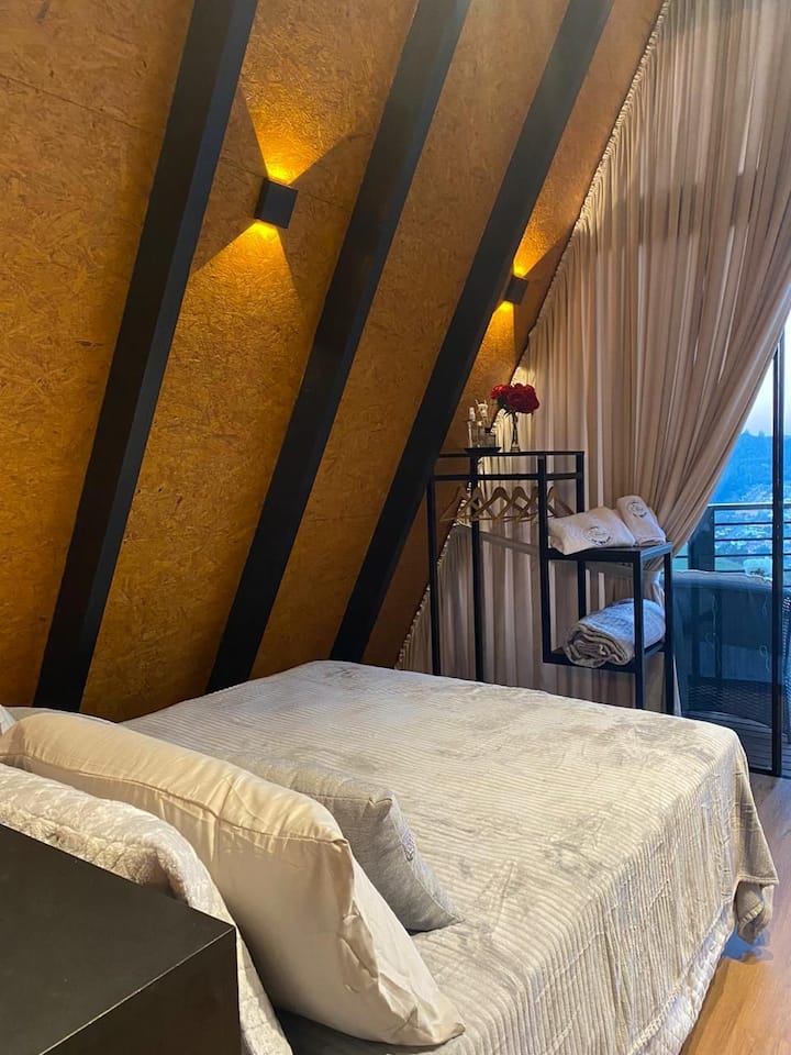 Quarto com cama feita e espaço para mala