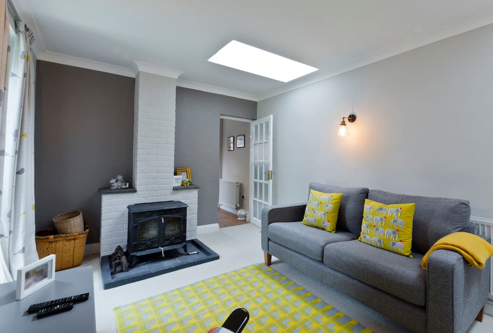 Spacious lounge area with large TV and log burner.