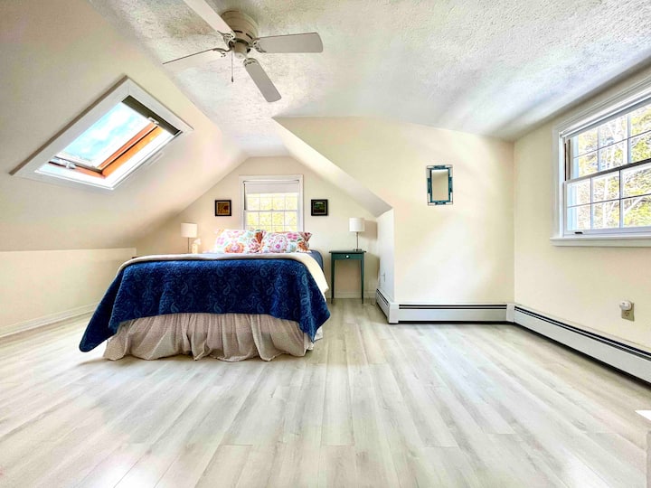 Duerme bien bajo los aleros en el dormitorio 2 con cortinas que oscurecen la habitación o lee durante el día en este dormitorio de arriba lleno de luz con vistas a los árboles de hoja perenne y los cielos más azules.